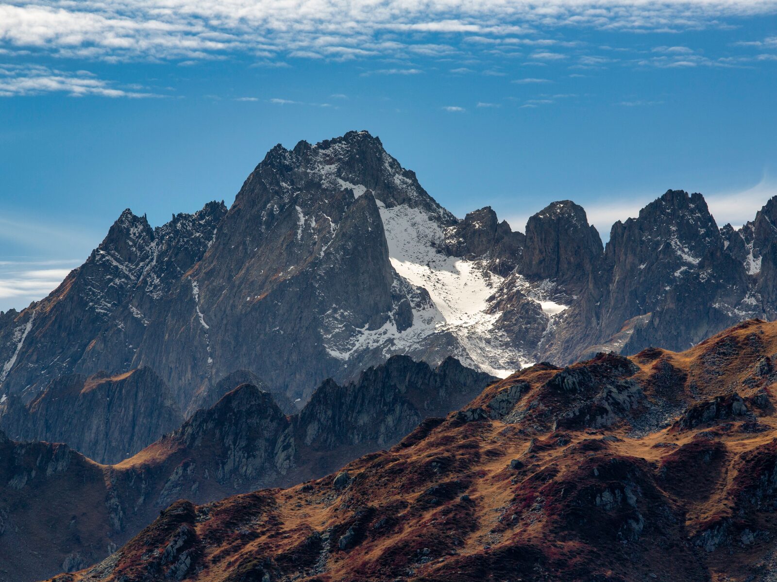 Alpengipfel im Herbstlicht, schneebedeckte Flanke unter klarem Himmel