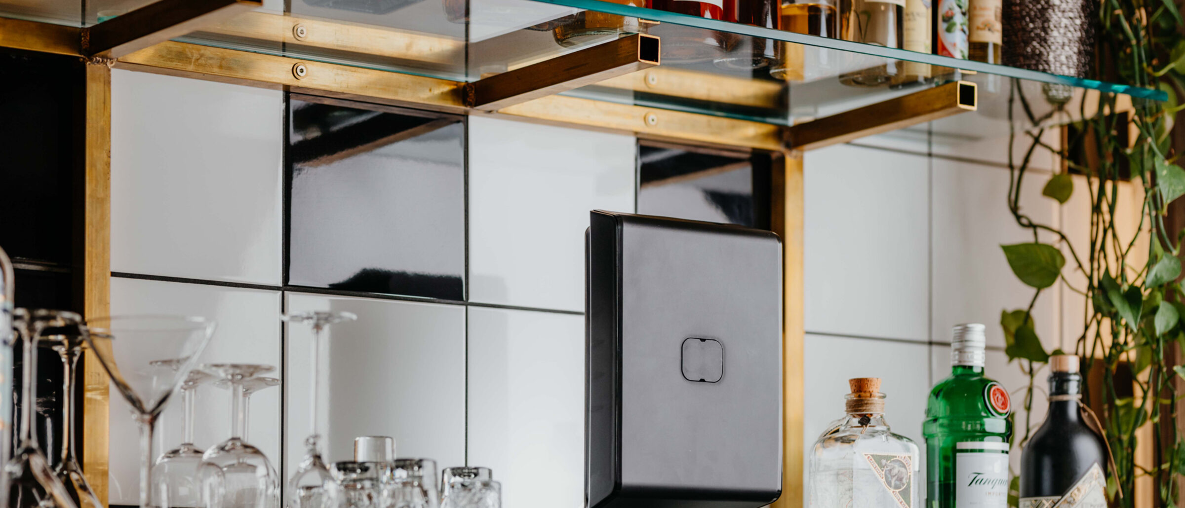 PRIME AirQ in Schwarz an einer Barwand, zwischen Gläsern und Flaschen